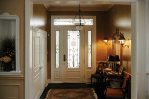 An elegant, white front door with intricate glass detailing seen from inside an entryway.
