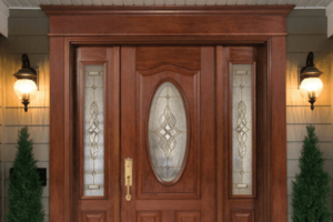 A beautiful red-brown wood front door with designed glass windows. 